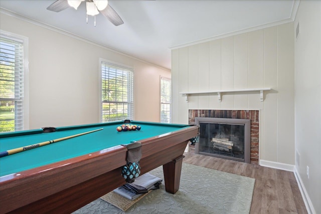 rec room with a fireplace, light hardwood / wood-style floors, ornamental molding, and pool table