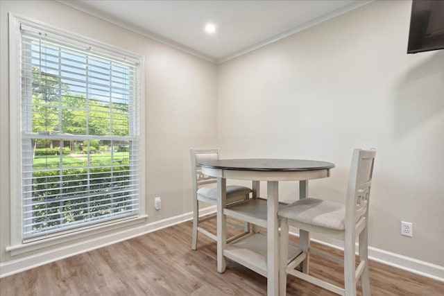 dining space with hardwood / wood-style flooring and ornamental molding