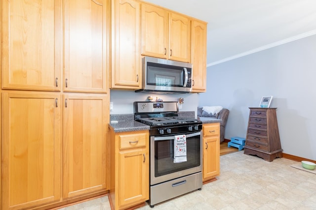 kitchen featuring appliances with stainless steel finishes, light brown cabinetry, dark stone counters, and ornamental molding