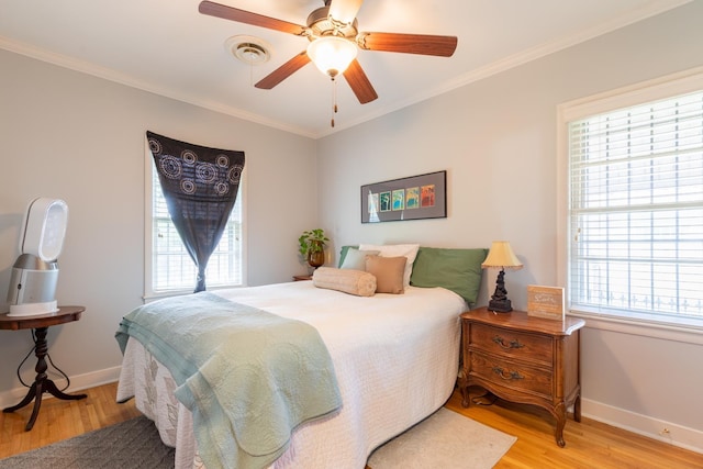 bedroom with ceiling fan, crown molding, and light hardwood / wood-style flooring