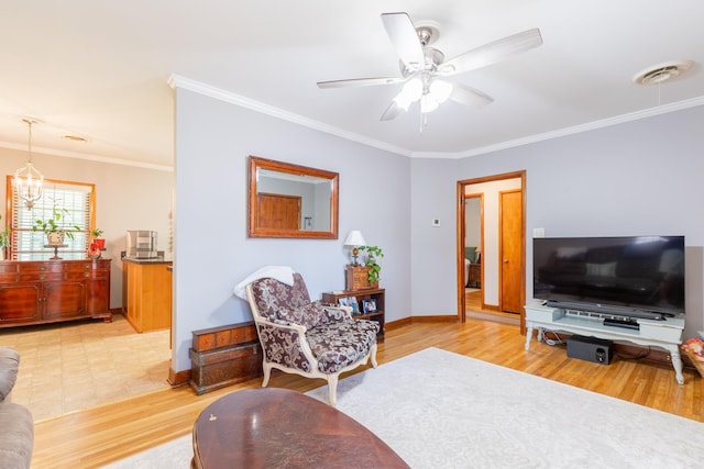 living room with ceiling fan with notable chandelier, light hardwood / wood-style flooring, and ornamental molding