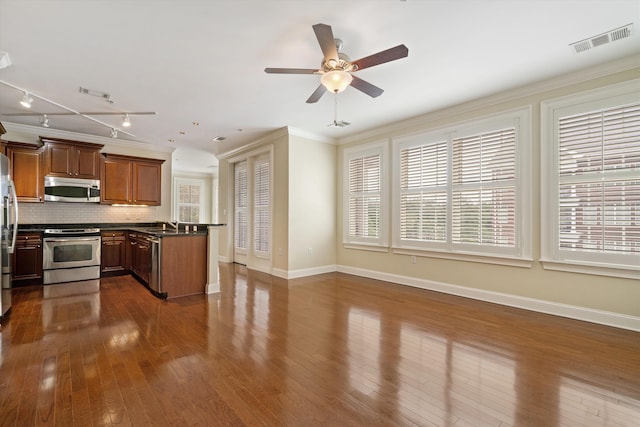 kitchen featuring decorative backsplash, stainless steel appliances, ceiling fan, dark wood-type flooring, and crown molding