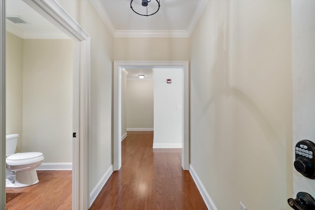 hallway with hardwood / wood-style flooring and crown molding