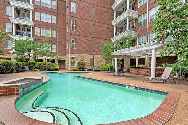 view of pool with a patio, a pergola, and a hot tub