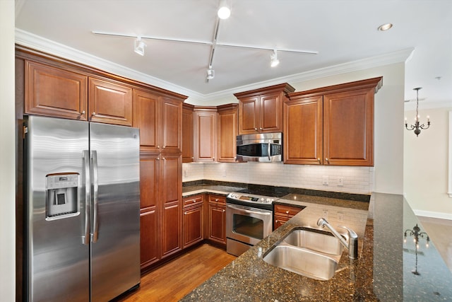 kitchen featuring sink, tasteful backsplash, a chandelier, dark stone counters, and appliances with stainless steel finishes