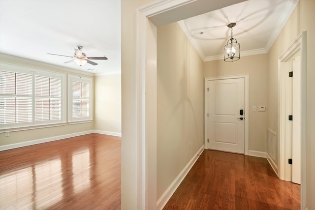 doorway featuring ceiling fan with notable chandelier, hardwood / wood-style flooring, and ornamental molding