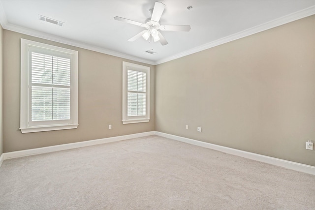 empty room with ceiling fan, light colored carpet, and ornamental molding