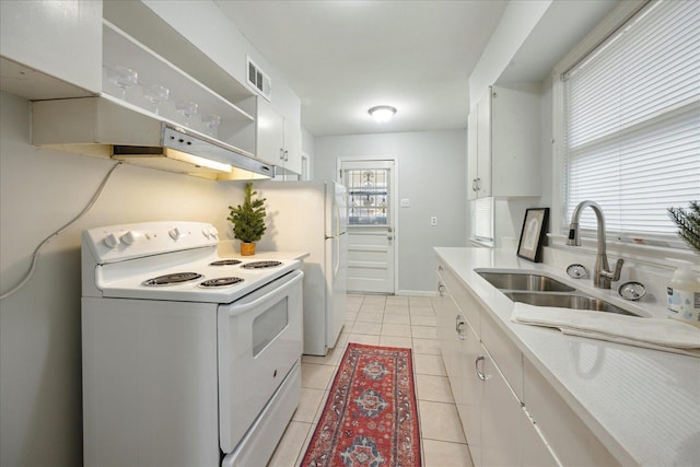 kitchen featuring white range with electric cooktop, sink, white cabinets, and light tile patterned flooring