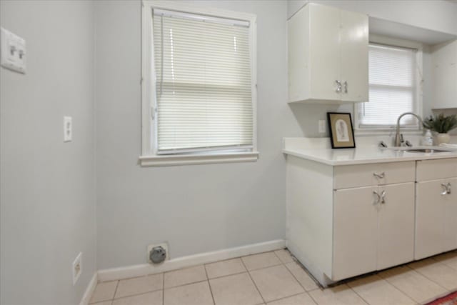 kitchen with sink, white cabinets, and light tile patterned flooring