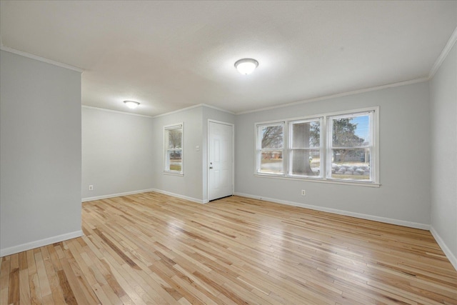 empty room with ornamental molding and light wood-type flooring