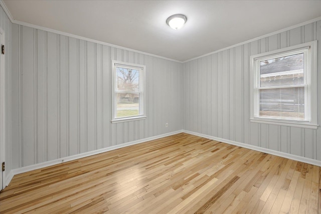 spare room with crown molding and light hardwood / wood-style floors