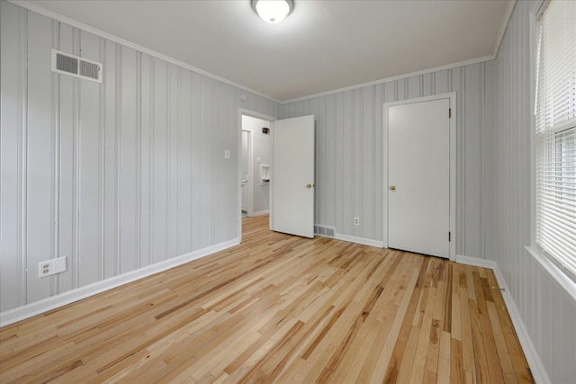 unfurnished bedroom with light hardwood / wood-style floors and ornamental molding