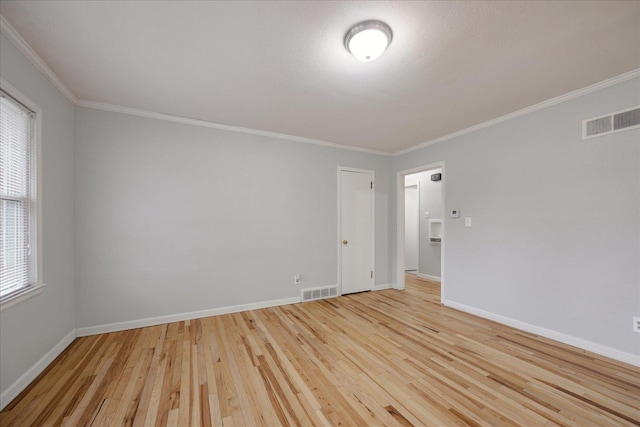 spare room with light wood-type flooring and ornamental molding