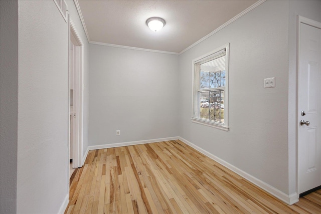 empty room featuring ornamental molding and light hardwood / wood-style flooring