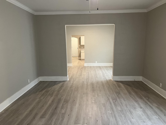 empty room featuring crown molding and wood-type flooring