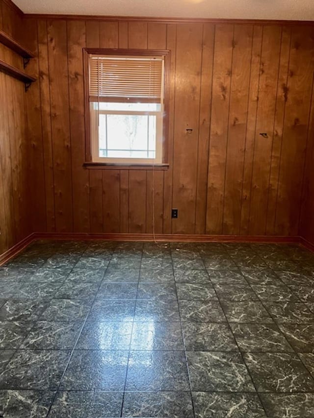 spare room with a textured ceiling and wood walls