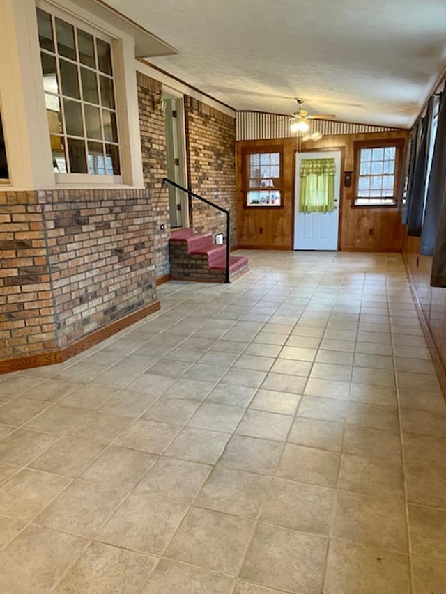 entrance foyer featuring wooden walls and brick wall