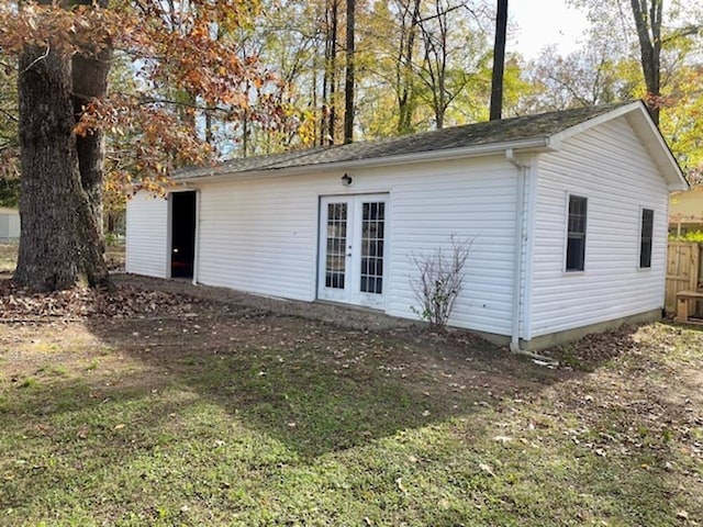 rear view of property with a lawn and an outbuilding