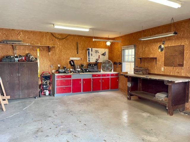 garage with a workshop area and wooden walls