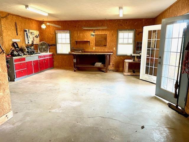 interior space featuring a workshop area, wood walls, and french doors