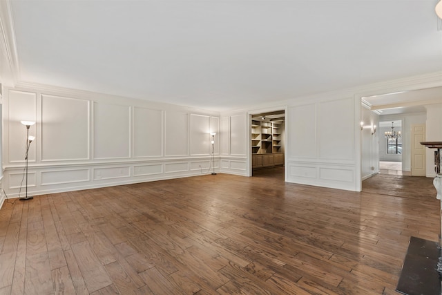 unfurnished room with a notable chandelier and dark hardwood / wood-style floors