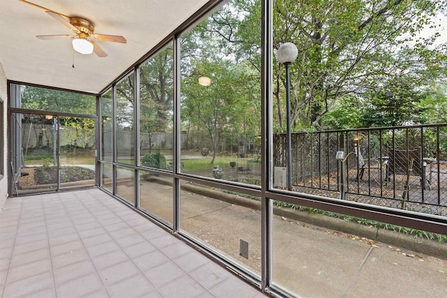 unfurnished sunroom featuring a wealth of natural light and ceiling fan