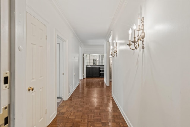 hall with dark parquet floors and ornamental molding