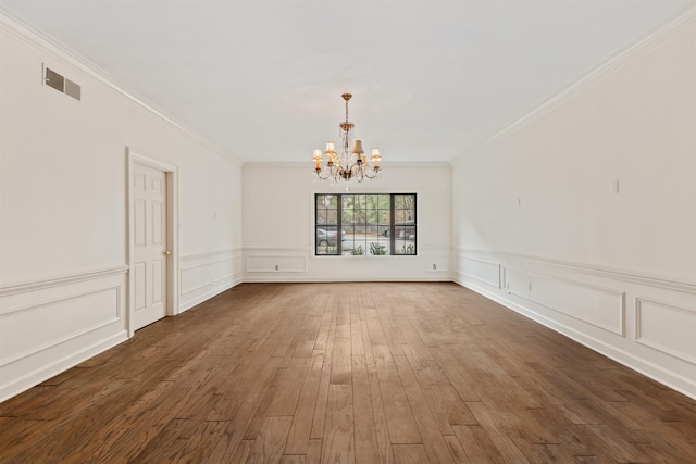 unfurnished dining area featuring dark hardwood / wood-style flooring, a chandelier, and ornamental molding