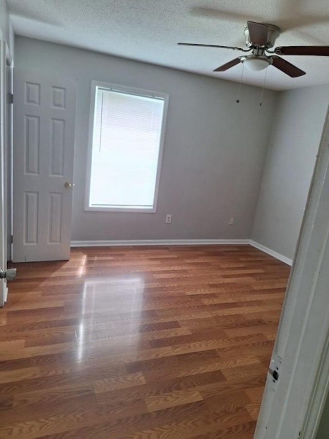 spare room featuring ceiling fan, dark hardwood / wood-style flooring, and a textured ceiling