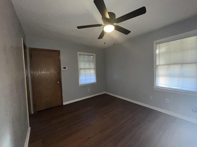 unfurnished room featuring ceiling fan, dark hardwood / wood-style flooring, and plenty of natural light