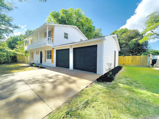 view of front of home with a garage, a balcony, and a front yard