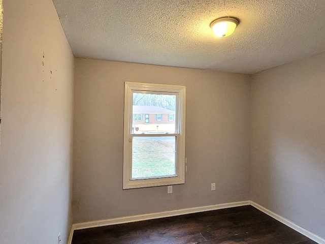 spare room with dark hardwood / wood-style flooring and a textured ceiling