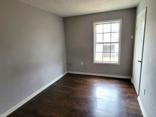 empty room featuring dark hardwood / wood-style floors, a healthy amount of sunlight, and a textured ceiling