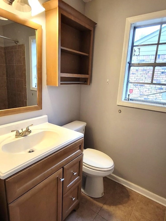 bathroom with toilet, a shower, vanity, and tile patterned floors