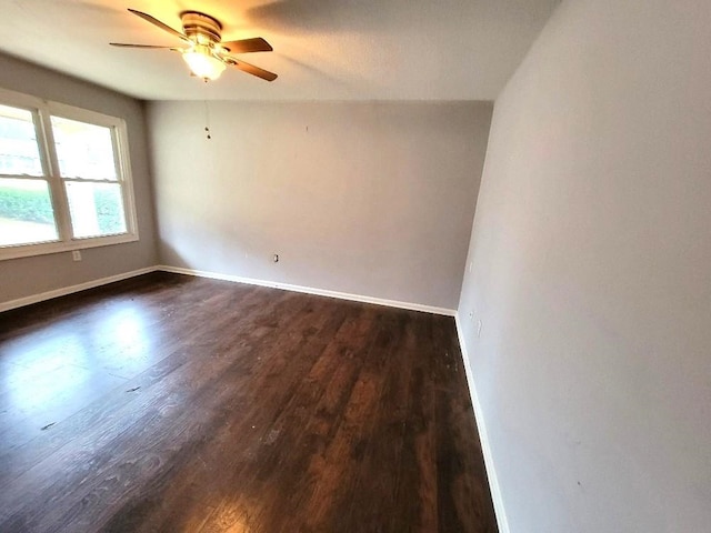 empty room with ceiling fan and dark hardwood / wood-style flooring