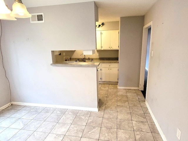 kitchen featuring light tile patterned floors, white cabinetry, hanging light fixtures, and sink