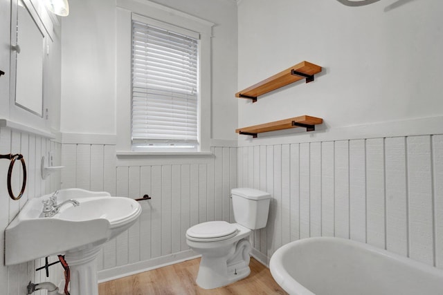 bathroom with hardwood / wood-style floors, sink, toilet, and a bath