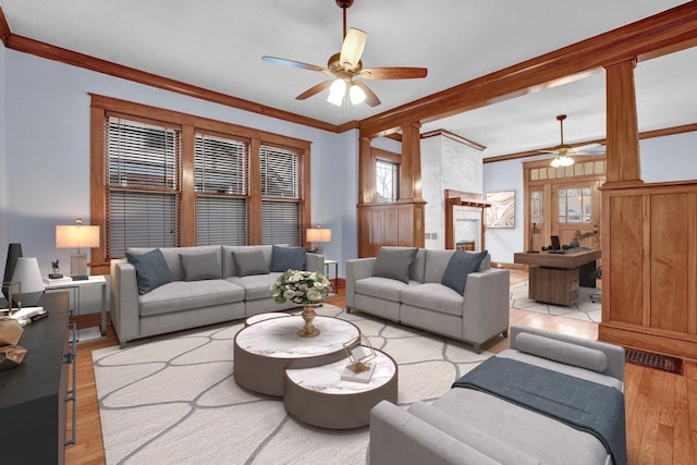 living room with light hardwood / wood-style flooring, ceiling fan, and crown molding