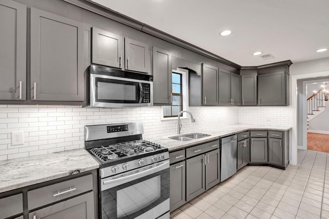 kitchen with light stone countertops, sink, appliances with stainless steel finishes, and tasteful backsplash