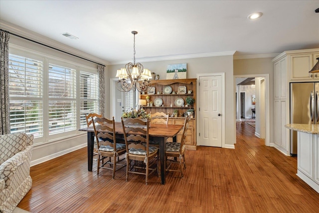 dining room featuring dark wood-type flooring, an inviting chandelier, and ornamental molding