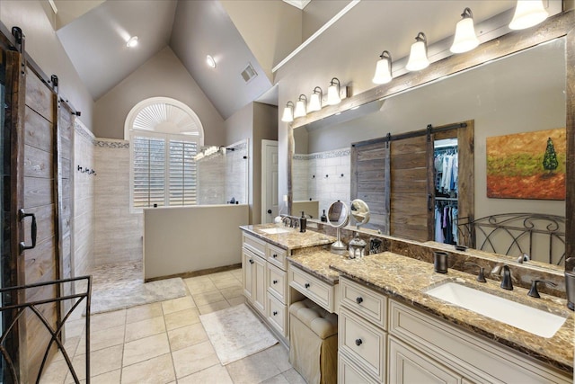 bathroom featuring tile patterned floors, vanity, a tile shower, and high vaulted ceiling