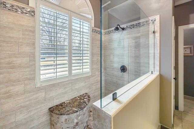 bathroom with a tile shower and plenty of natural light