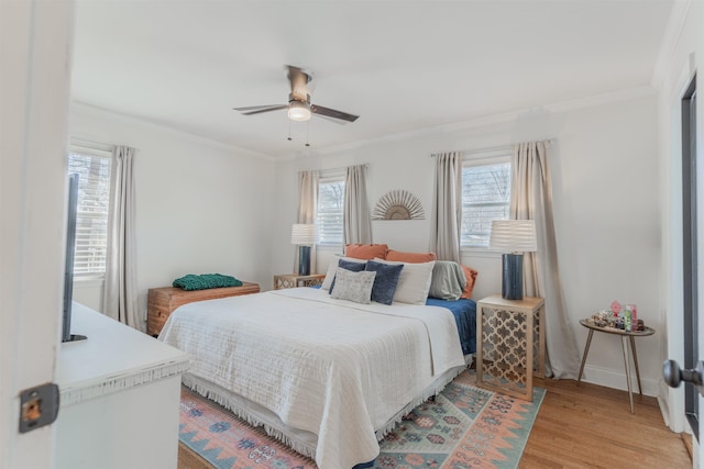 bedroom featuring ceiling fan, light hardwood / wood-style floors, and crown molding