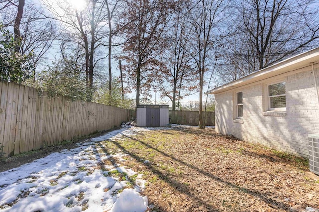 snowy yard featuring a shed