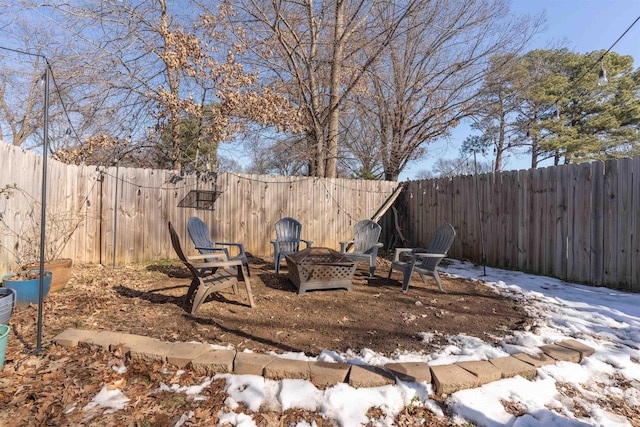 yard layered in snow with an outdoor fire pit