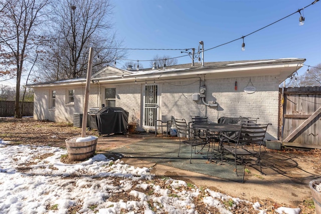 snow covered rear of property with a patio