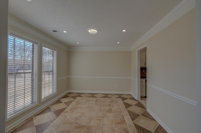 empty room with ornamental molding, a textured ceiling, and light tile patterned floors