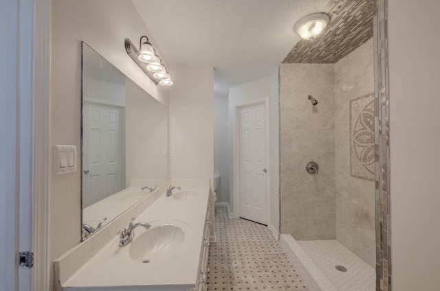 bathroom featuring a tile shower, vanity, and toilet