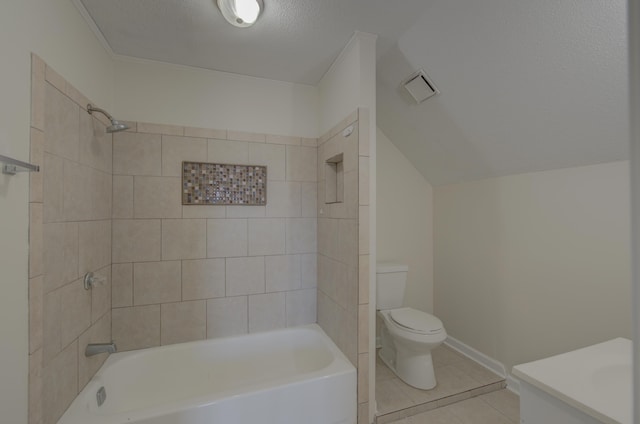 full bathroom featuring tile patterned floors, a textured ceiling, tiled shower / bath combo, vanity, and toilet