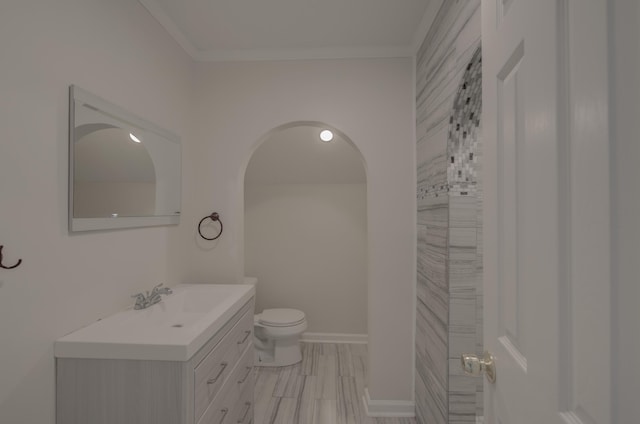 bathroom featuring toilet, vanity, and ornamental molding